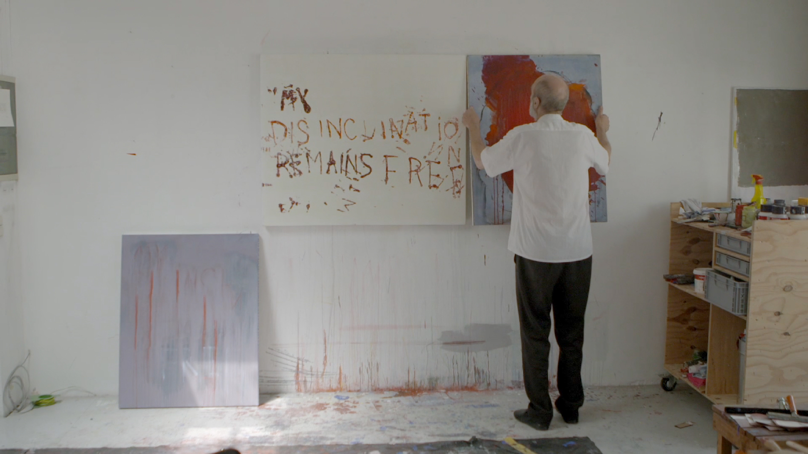 Homme accrochant un tableau sur un mur
