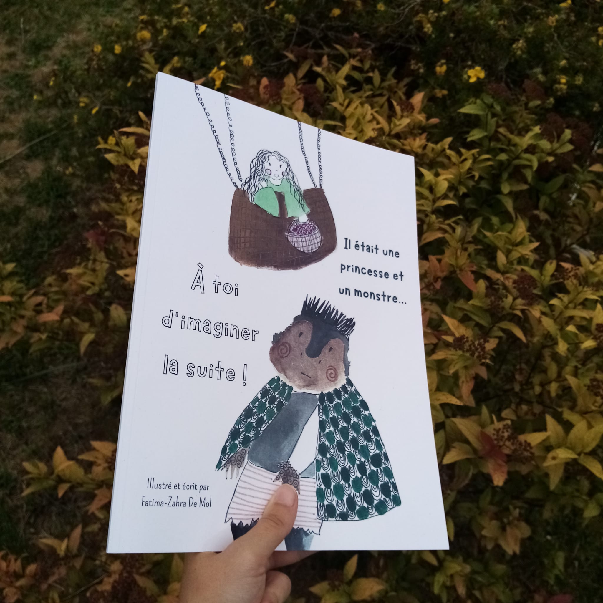 Photo d'une main tenant une illustration avec une princesse et un monstre